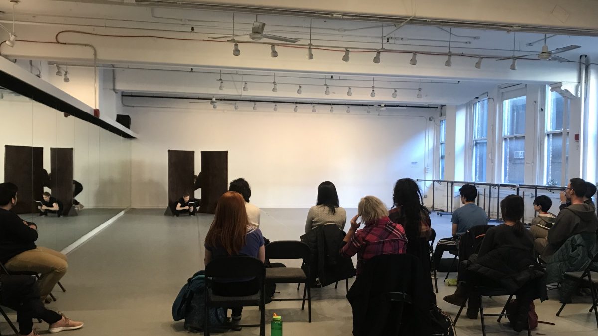 Audience watching performance in a dance studio.