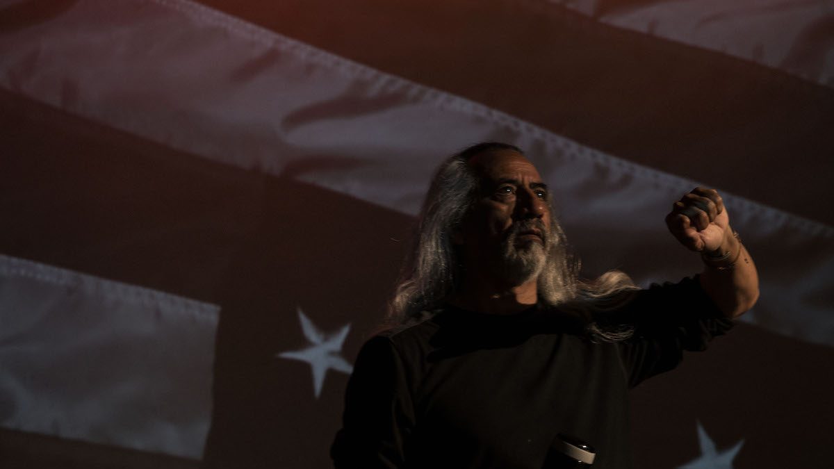 Man looking boldly away from the American flag.