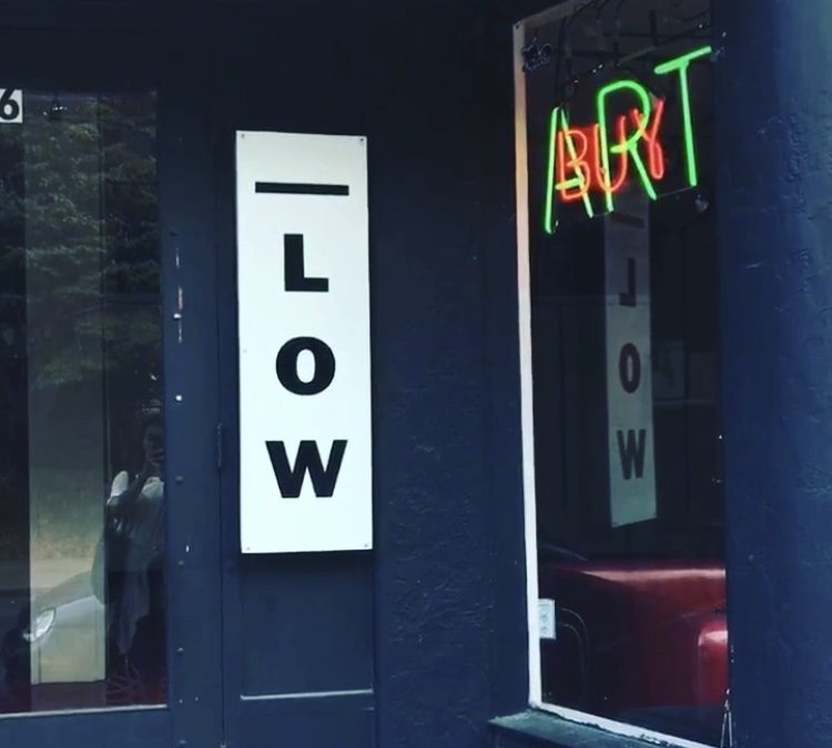 A door with two signs that reads "Low Art"
