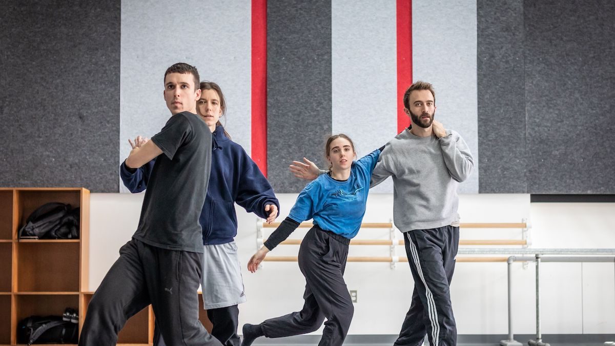 Group of white dancers moving in a dance studio.