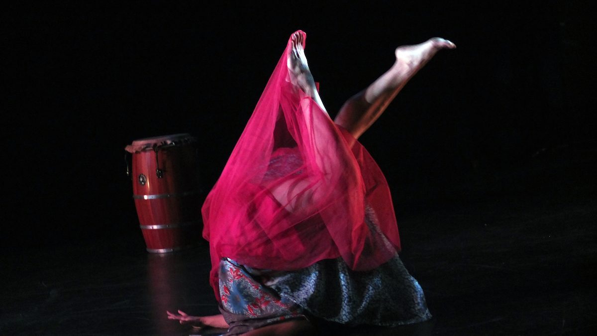 Woman in a red skirt, upside down on the floor.