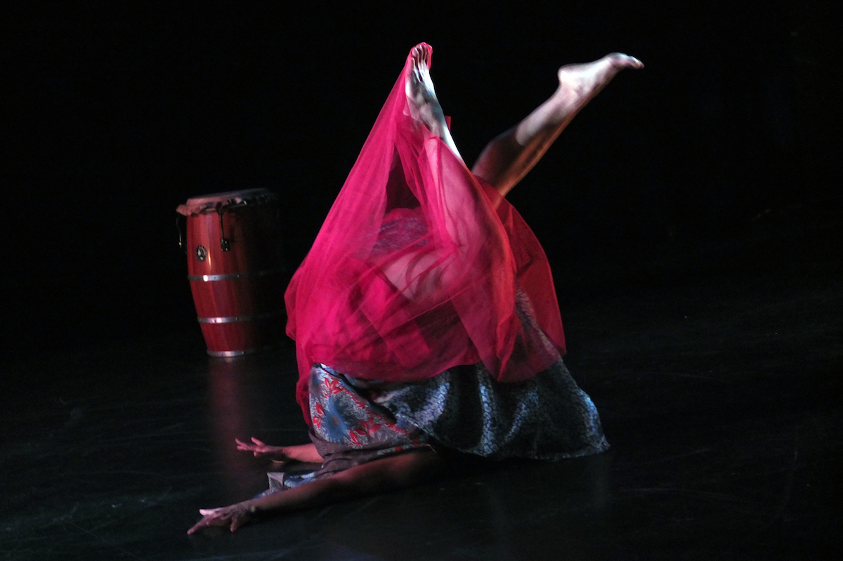 Woman in a red skirt, upside down on the floor.