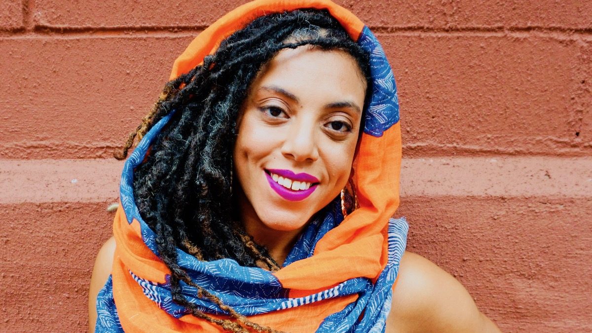 woman of color smiling at the camera.