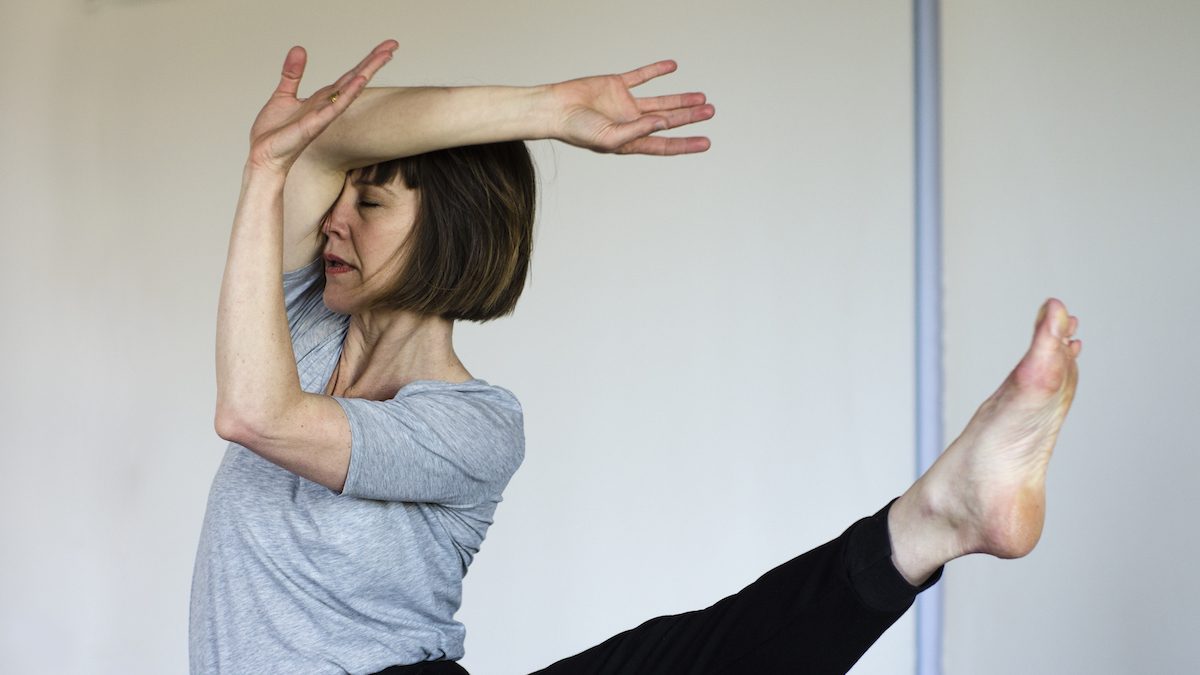 Woman dancing mid-motion in a rehearsal.