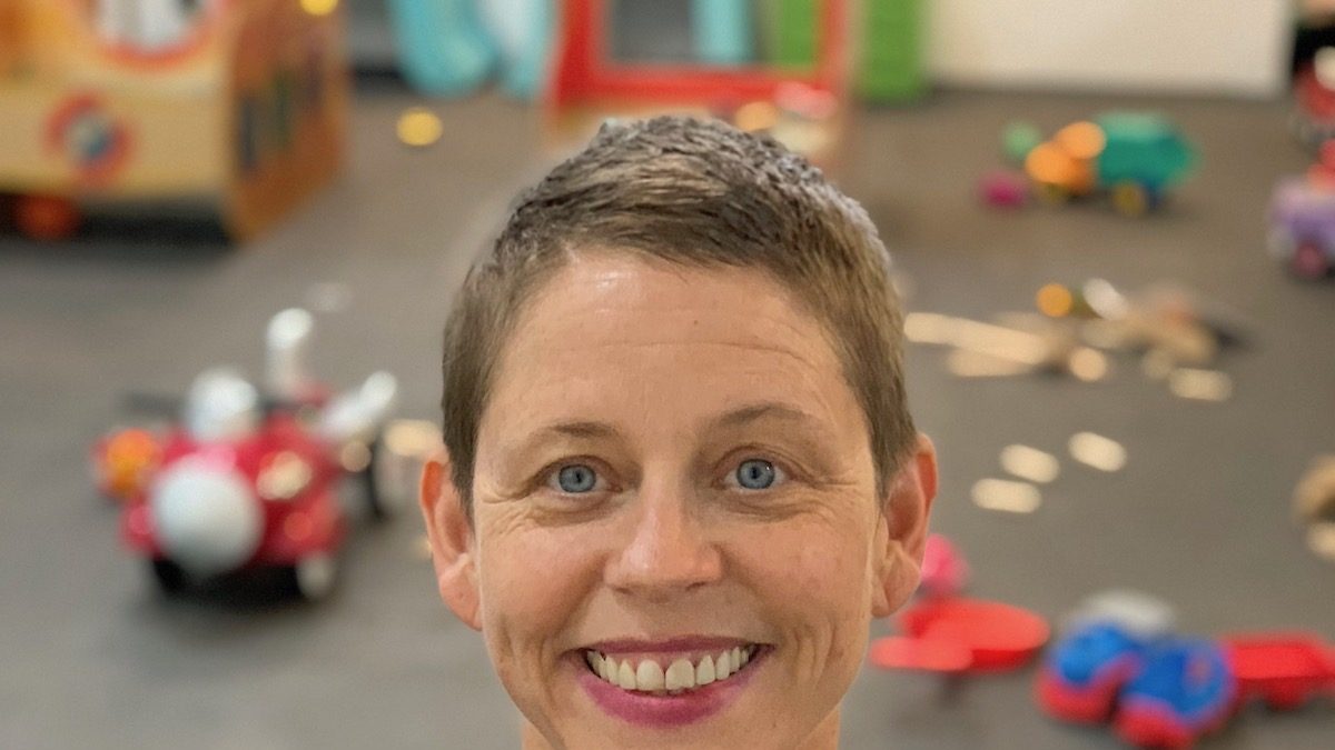 White woman smiling at the camera.
