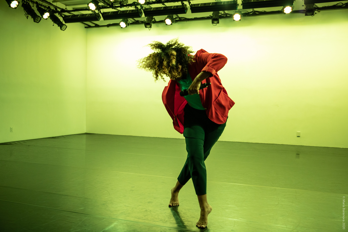 Woman dancing on stage in a lime green light.