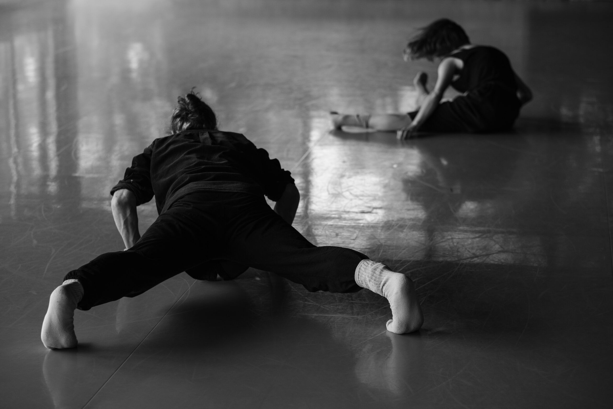 Black and white photo of a dancer on moving into the floor.