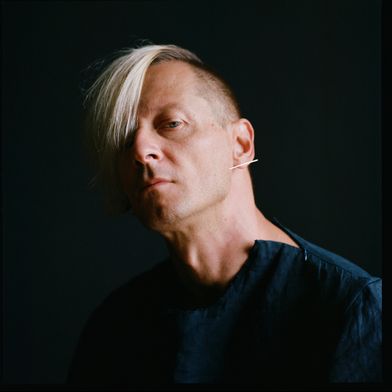 Photo by Maria Baranova. Image shows the author of the article, a fair-skinned male with light blond hair wearing a dark top against a black background.